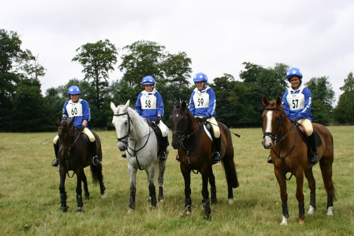 The Burghley Pony Club Team in royal blue rugby shirts with printing & stars hat silks.