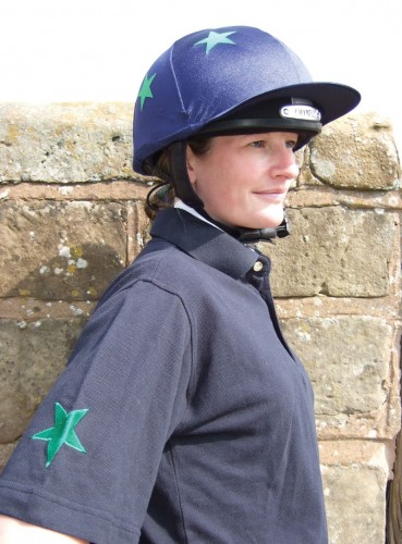 Sophie in a dark blue bespoke polo shirt with emerald green star design and matching lycra cap.
